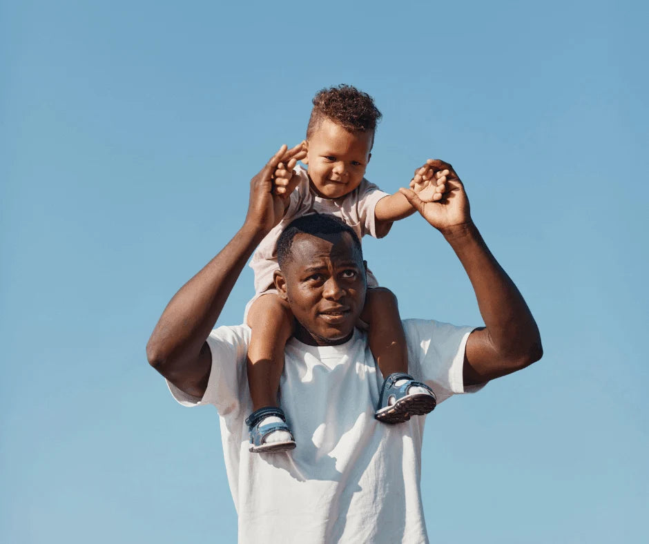 Father’s Day Gift Ideas for Wellness-Minded Dads - dad carrying child on shoulders against blue sky