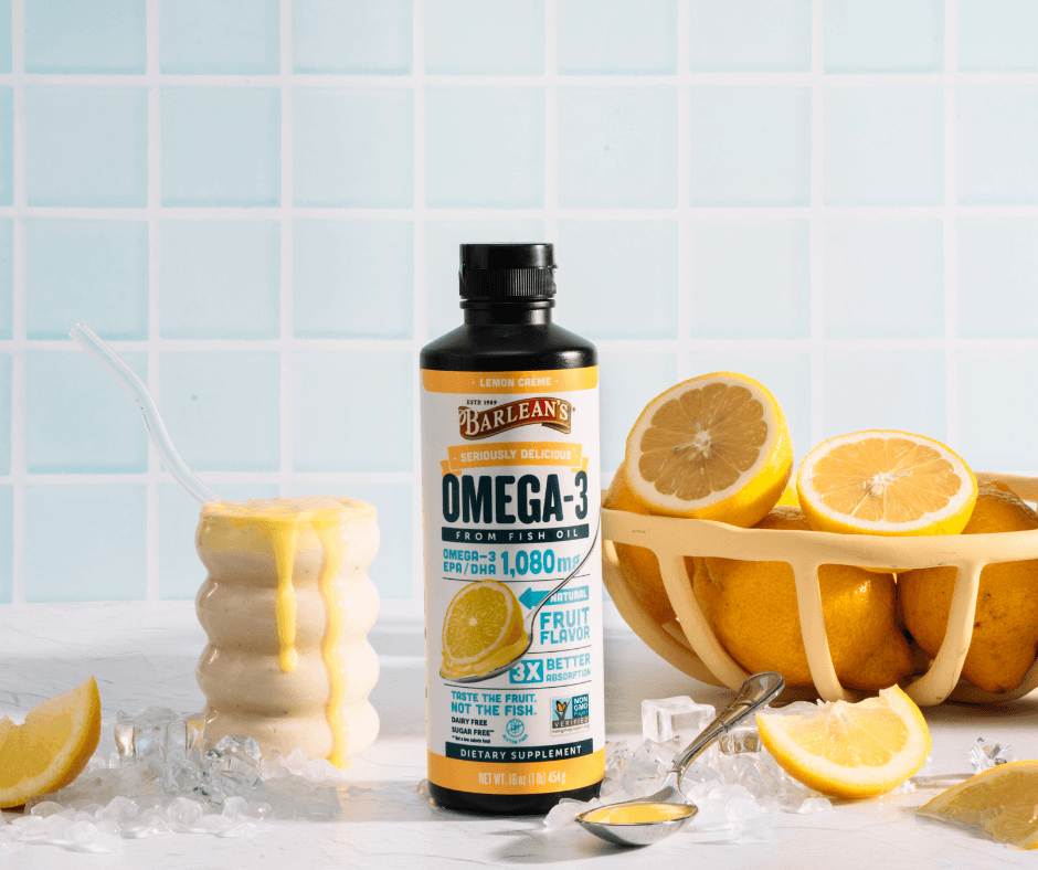 barlean's lemon creme omega 3 fish oil bottle on the counter with juicy lemons all around it