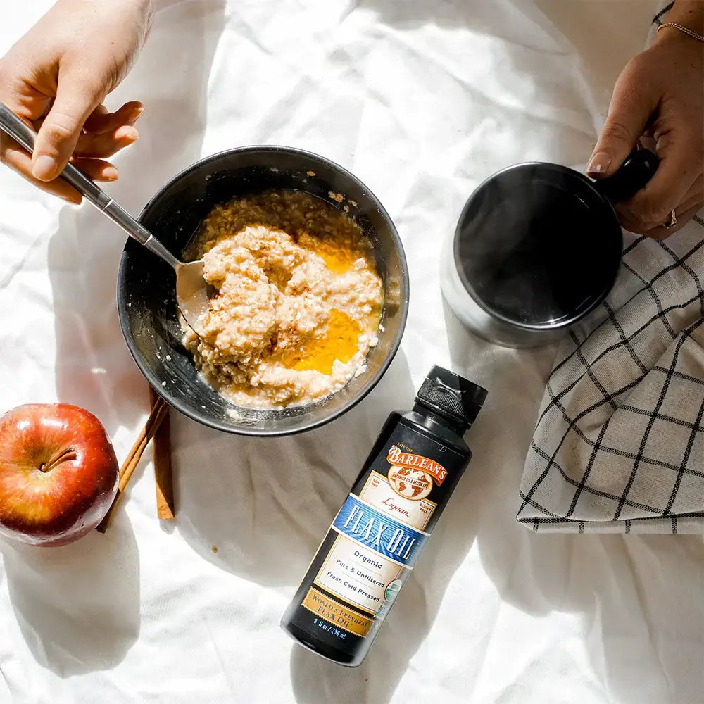 Barlean's Fall Oatmeal Recipe with an apple and fish oil next to the bowl