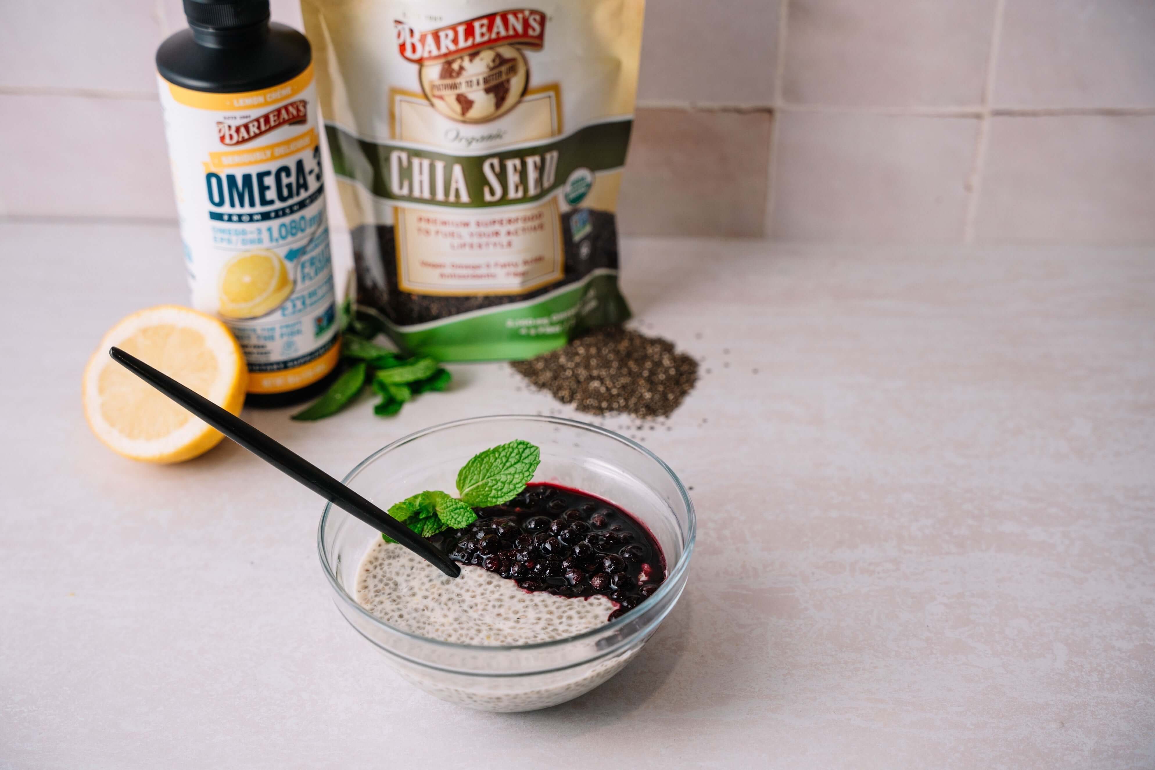 lemon berry chia seed pudding on the counter with barleans products behind