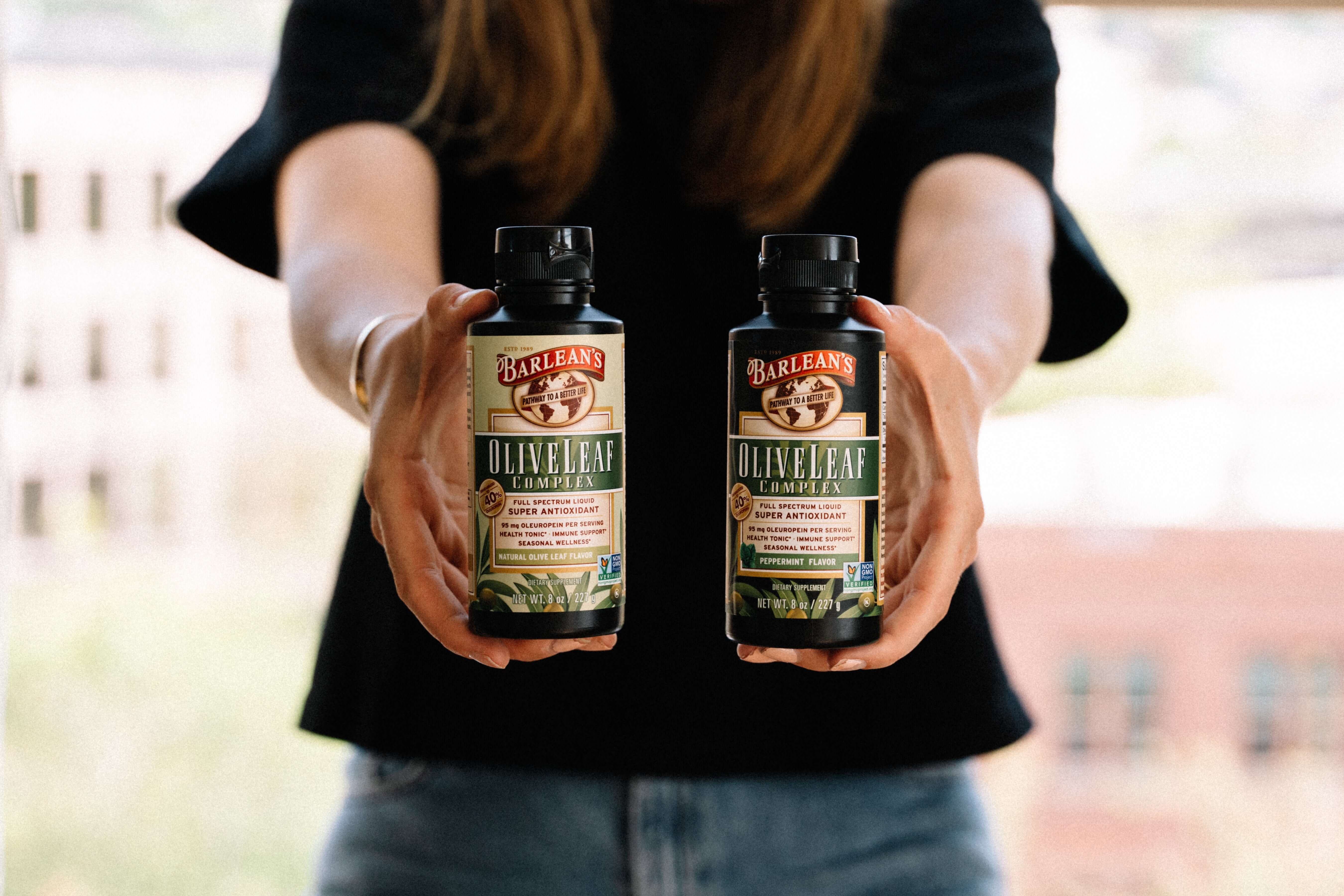 pictures of someone holding barlean's olive leaf immune support products
