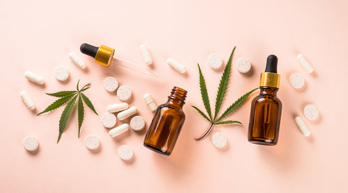 Image: Pills, hemp leaves and tincture bottle laying flat on table