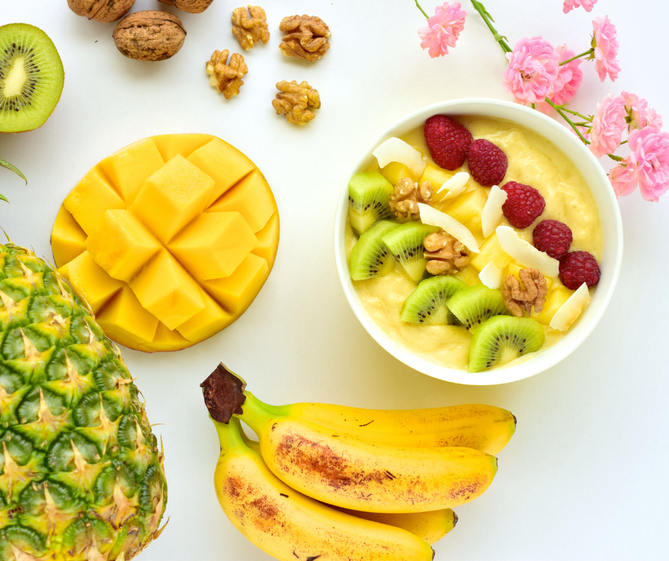 Tropical Breakfast Parfait surrounded by kiwis, mango, pineapple
