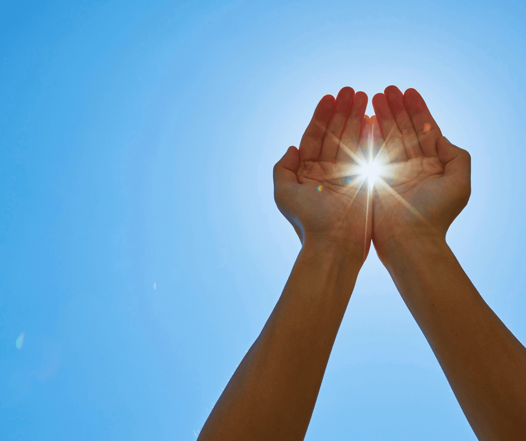 a blue sky with hands encompassing the sun