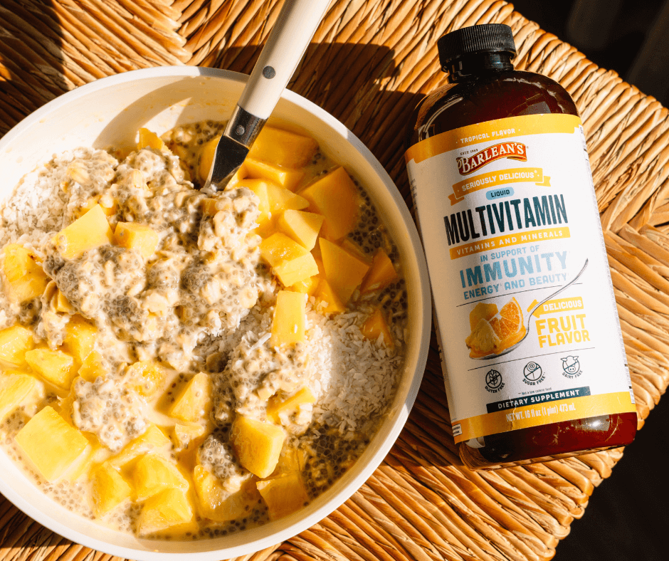 Picture of Barlean's Tropical Liquid Multivitamin drizzled on top of a bowl of oatmeal with fresh tropical fruit, chia seeds, and shaved coconut