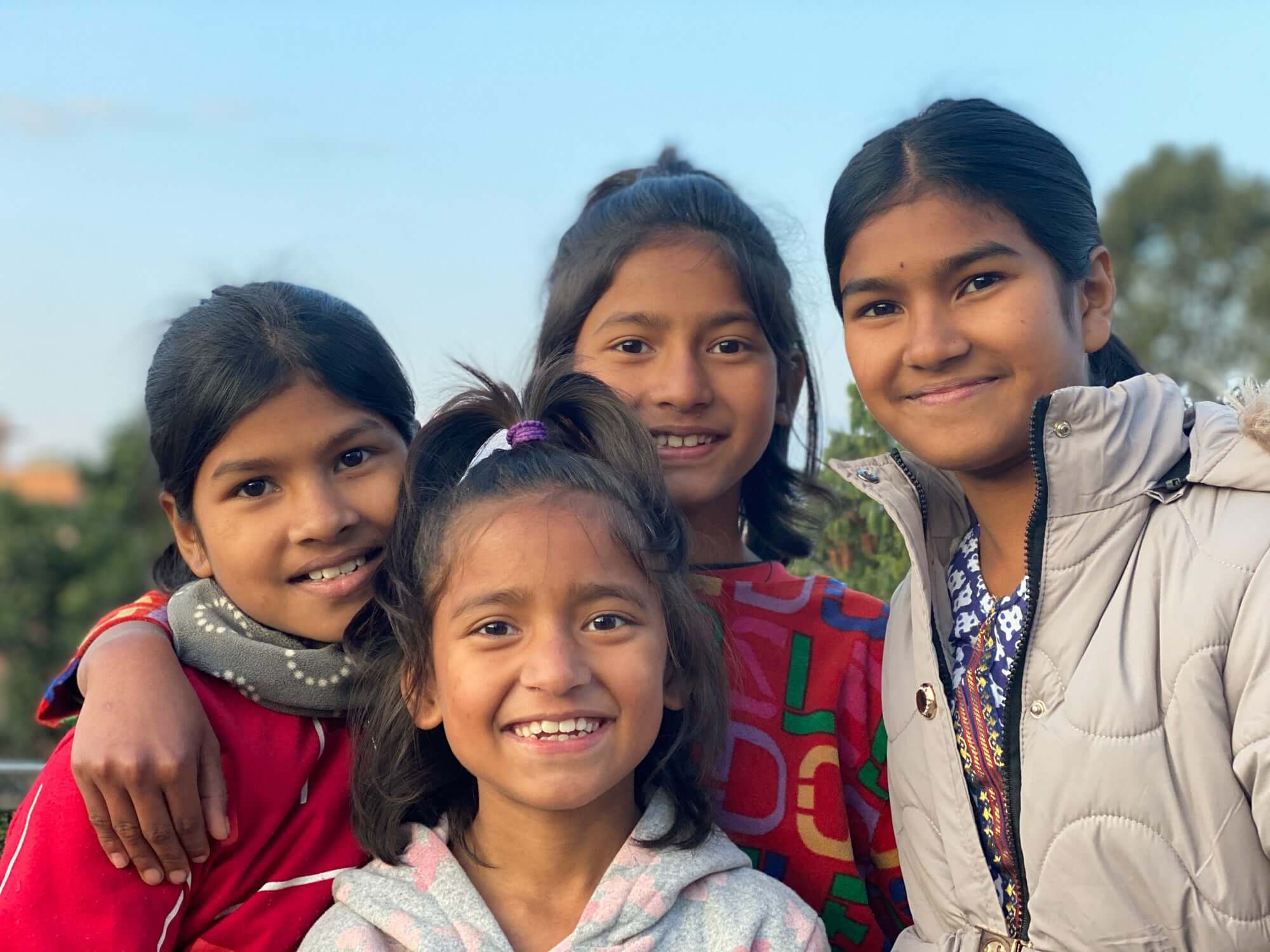 four girls around ages 7 to 12 standing together