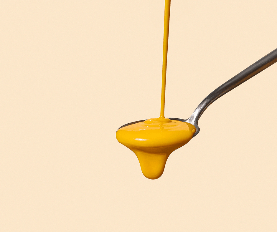 Spoon with yellow liquid dripping off, representing what ingredients to look for in a quality multivitamin.