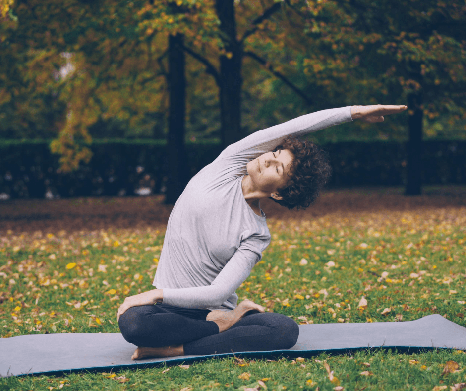 a woman outside during fall doing a yoga pose