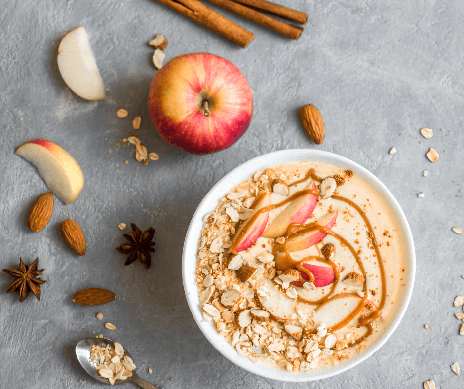 apple cinnamon chocolate greens smoothie bowl on counter with apples, cinnamon, and star anise surrounding it