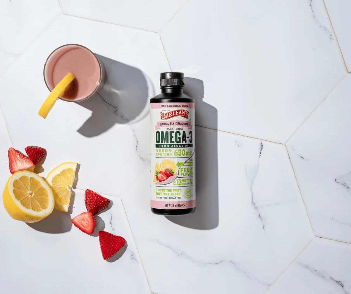 Bottle of plant-based Omega-3 from algae oil next to a fruity smoothie and fresh fruit, showcasing Module 8: Algae Oil (Plant-Based Omega-3s).