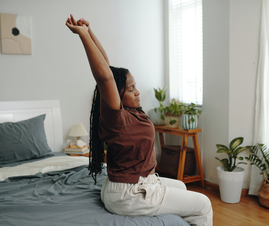 A woman stretches in bed, promoting The 10‑Minute Morning Routine for Women for a healthy start to the day.