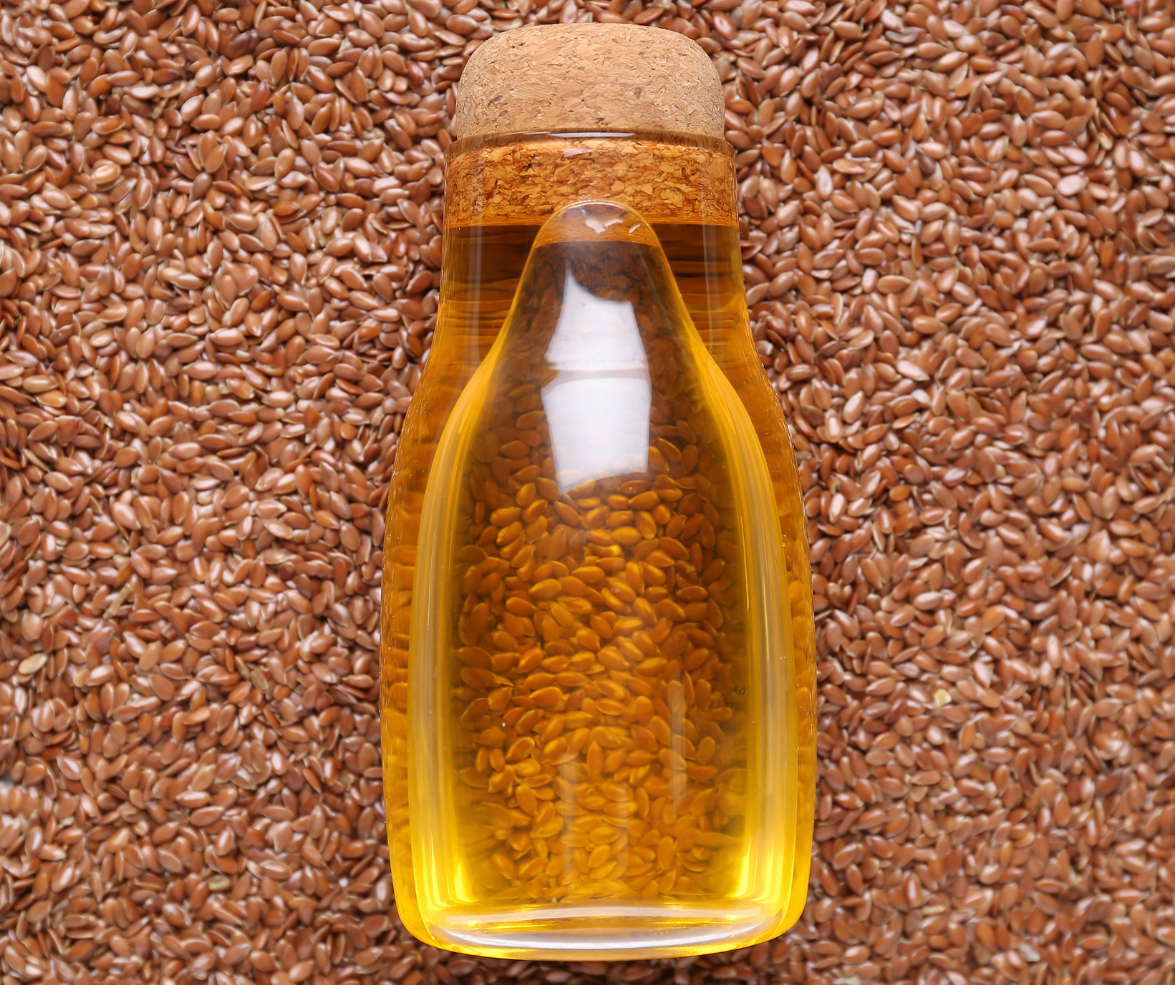 a small ampoule of flax oil laying on top of flaxseeds