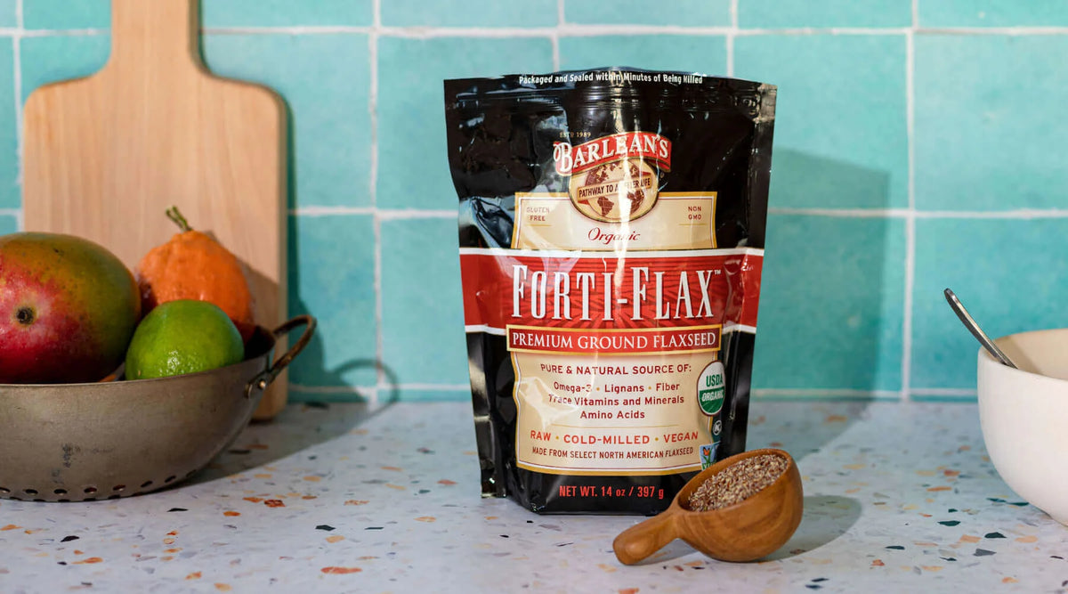 Easy Ways To Incorporate Flaxseed Into Your Diet with a bag of premium ground flaxseed and fresh fruits on a kitchen counter.